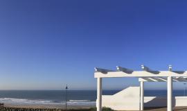 Vista de la playa desde un parador blanco de madera